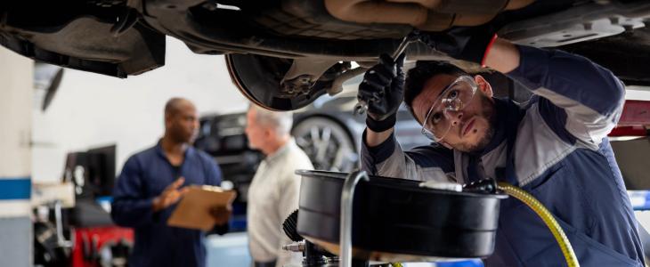 Auto mechanic working underneath a car