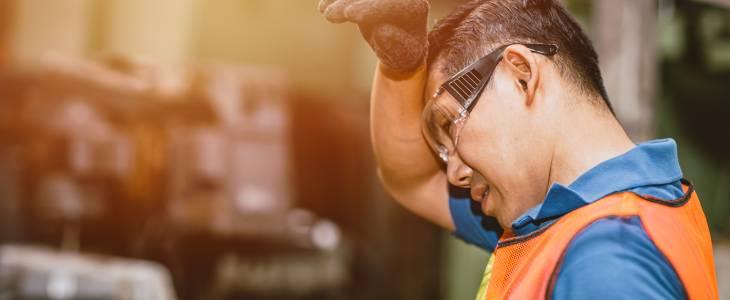 Tired worker wiping brow with forearm