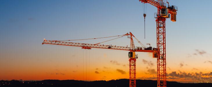Large building cranes at sunset