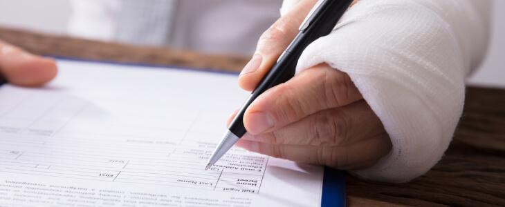 Man with case on hand signing an insurance form.